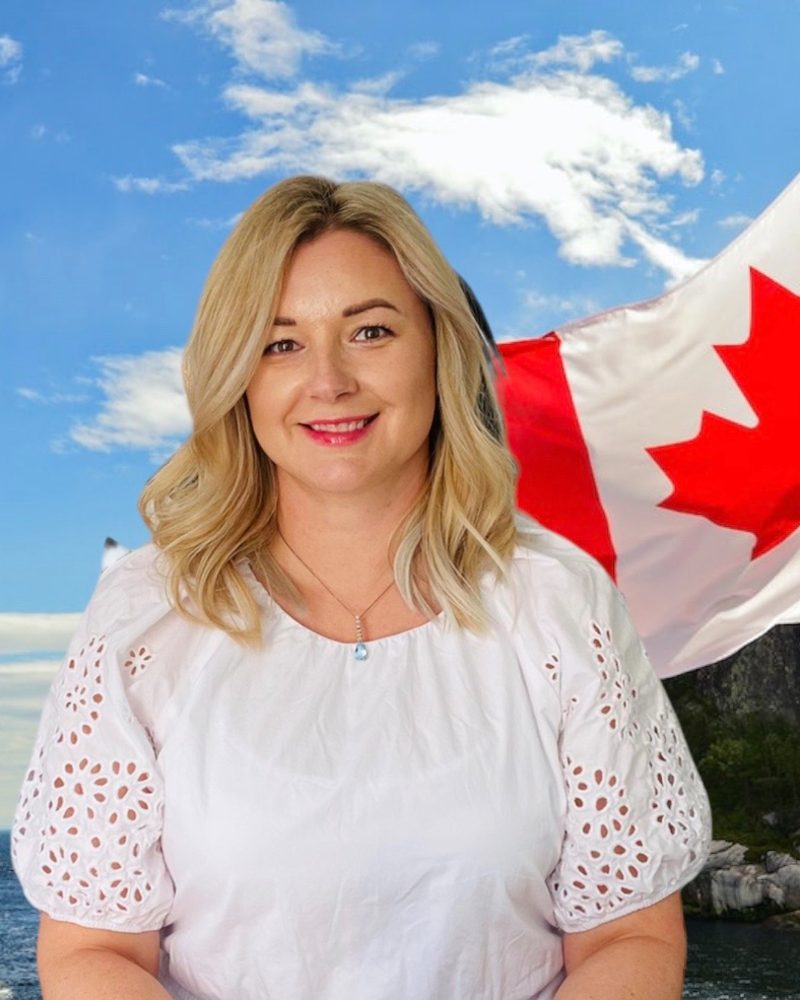 Veronika smiling in front of a Canadian flag